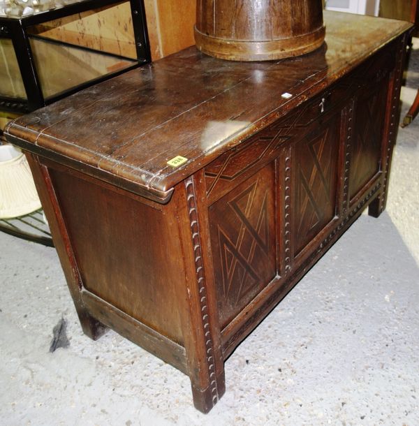 An 18th century oak lift top coffer with three panel front and carved decoration, 112cm wide. I5
