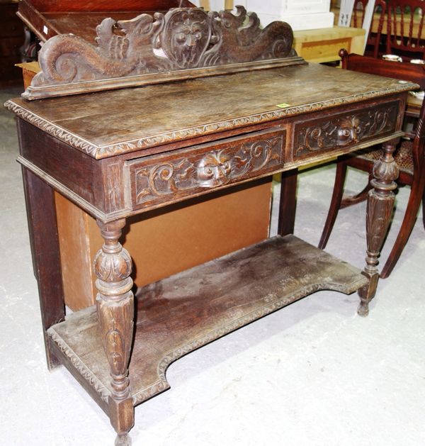 An early 20th century carved oak two tier side table, 106cm wide. E6