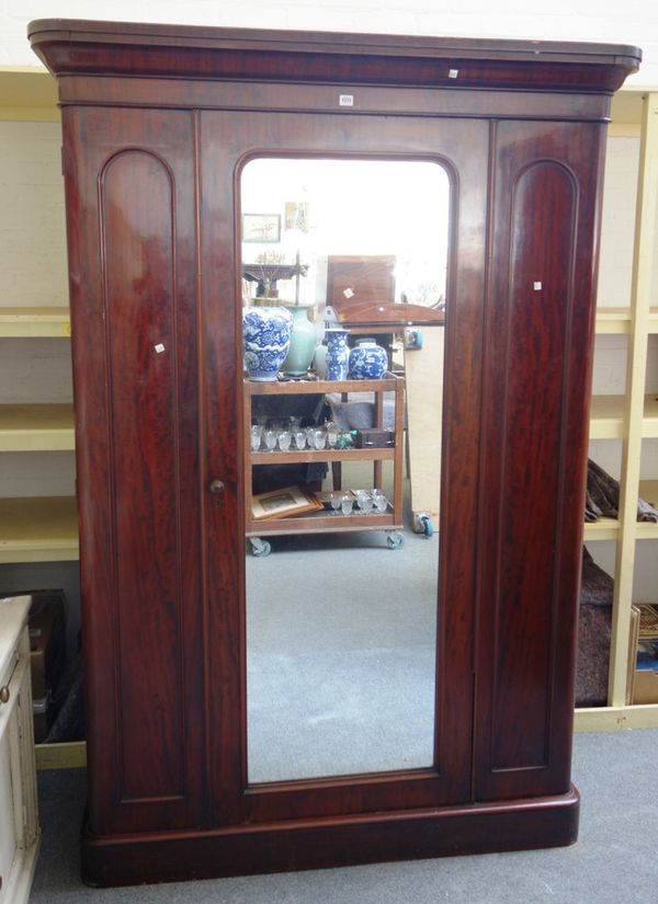 A Victorian mahogany wardrobe with single mirrored door, enclosing a fitted interior on a plinth base, 145cm wide x 212cm high. M2
