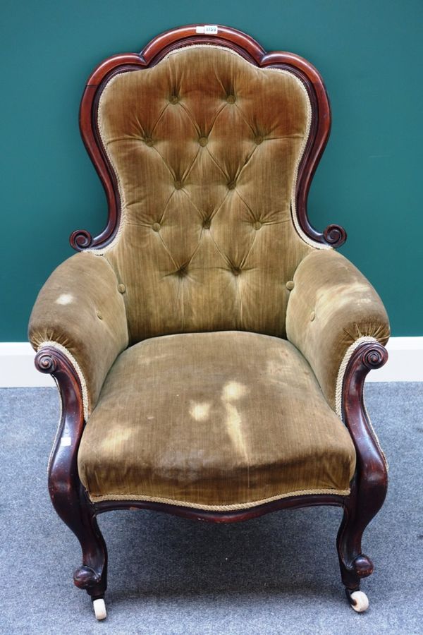 A Victorian walnut framed easy armchair, with serpentine seat on scroll supports. A6