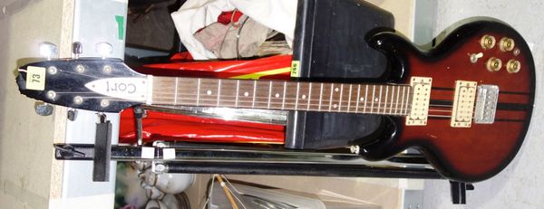 A 20th century Cort six string electric guitar with sun burst body together with a metal easel. S3M