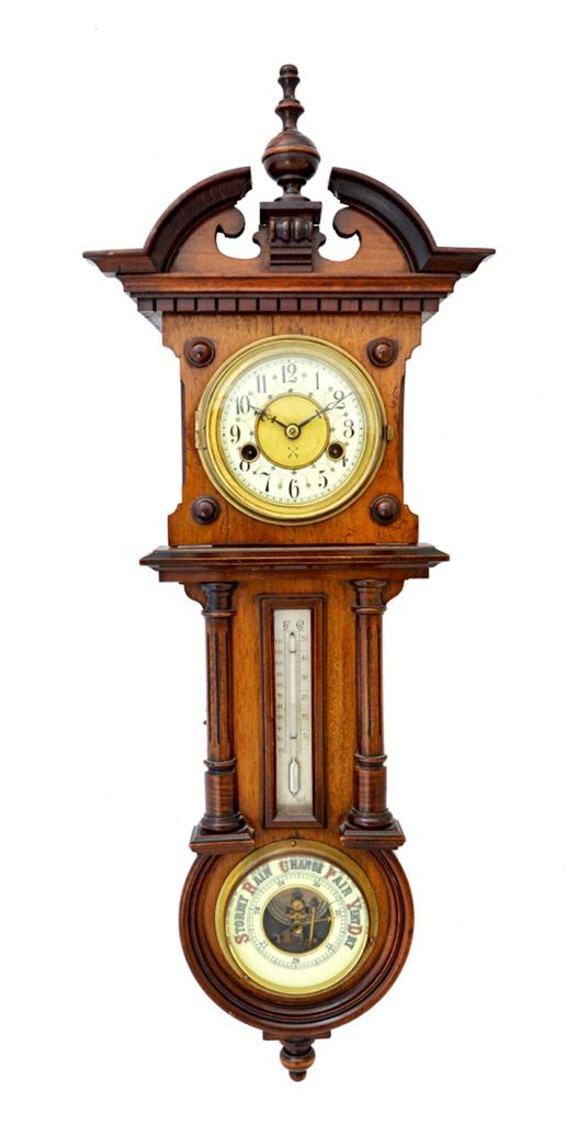 A Continental walnut cased wall clock compendium, circa 1900, with broken arch pediment and dental cornice over a clock, thermometer and barometer in