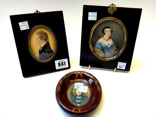 An early 19th century portrait miniature on paper, profile bust of a gentleman in an ebonised frame, 8cms high, a portrait miniature on ivory of a lad