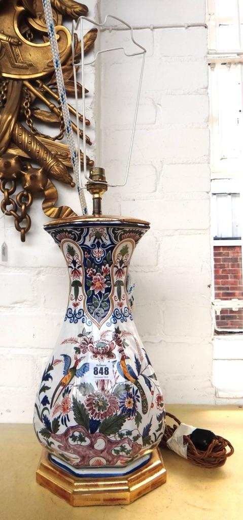 A French faience vase (converted to a table lamp), 19th century, decorated with flora and fauna against an octagonal baluster ground, on a giltwood ba