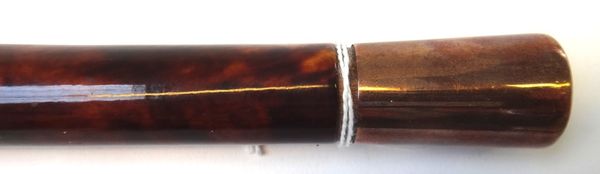 An Edwardian tortoiseshell veneered walking cane of cylindrical tapering form, with a gold plated pommel engraved 'E.D.J. Nov 1916', 97cm long.