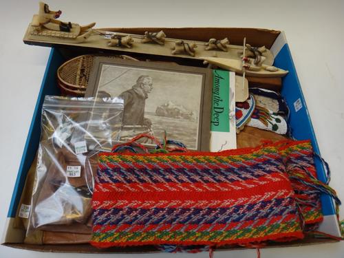 Three Inuit carvings depicting a husky group, 45.5cm, a man in a kayak, and one further figure with skis, together a pair of Inuit made leather boots,