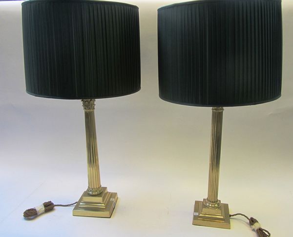 A pair of Victorian style gilt brass Corinthian column table lamps, 20th century, each on a stepped square base, with green silk pleated shades, 84cm