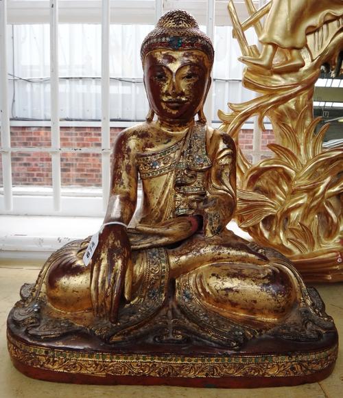 A polychrome and giltwood carved Buddha figure, South East Asian, 20th century, inset with coloured glass roundels, modelled atop an integral plinth,