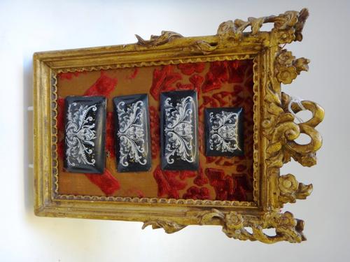 Four Limoges enamel on copper plaques, late 19th century, each of raised rectangular form, painted with masks and scrolling flora against a black grou