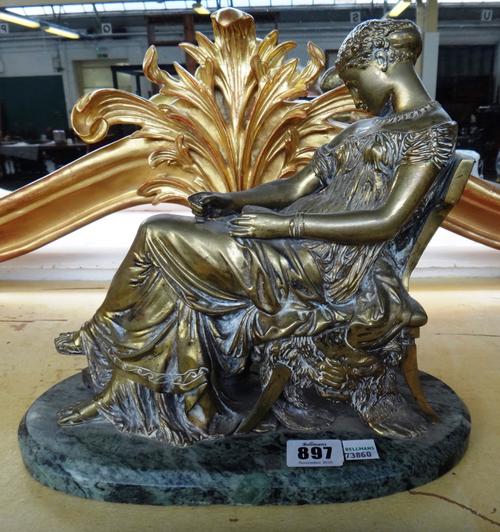 A 19th century gilt brass figure modelled and cast as a classically dressed female reclining in a chair, raised on an oval green marble plinth.  Prope