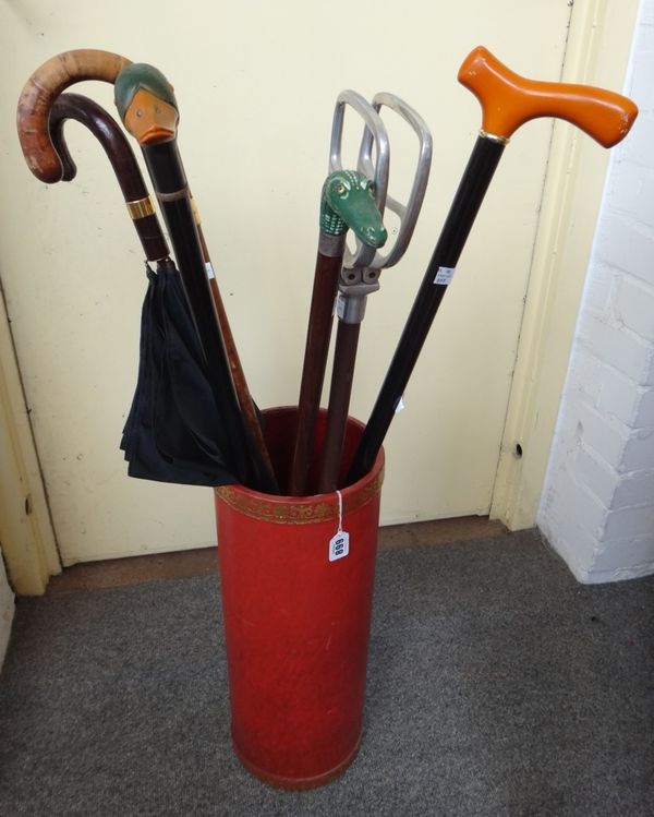 A collection of walking sticks and umbrellas, one with gilt metal band stamped 'Brigg London' and engraved 'Norman St. John Stevas', contained in a re