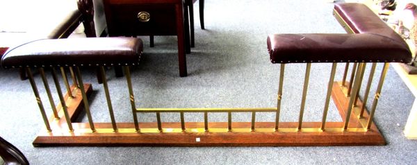 A Victorian style brass club fender, late 20th century, with burgundy faux leather cushioned seat on an oak plinth, 183cm wide.