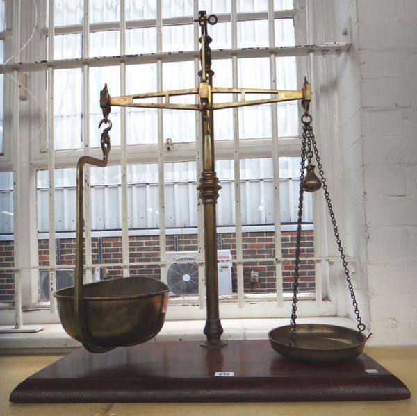A large set of Victorian brass pan scales, on a rectangular mahogany plinth, 79cm high.
