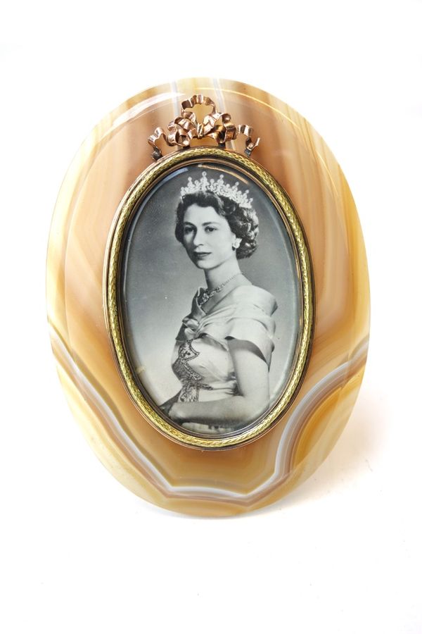 A silver gilt and gold mounted agate oval photo frame, the ivory back with scratched inventory number 55709 with silver strut support, bearing the mar