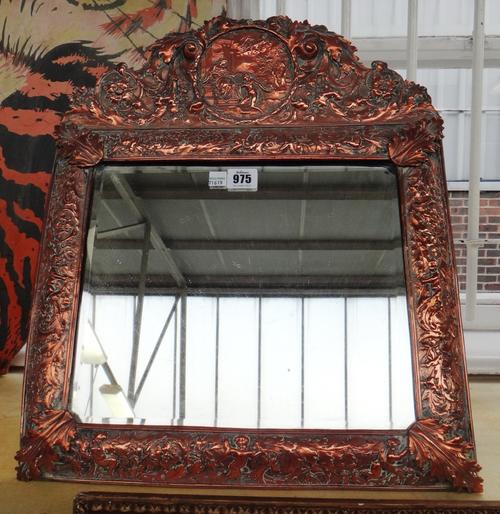 An embossed copper framed mirror, late 19th century after a model in the V&A, cast with classical figural scenes within a wide foliate border, with in