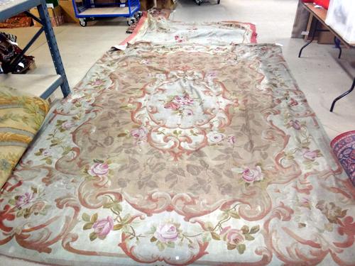 An Aubusson carpet, the beige field with an ivory cartouche of floral posy, shaped outer border of floral sprays, 383cm x 278cm.  Property from the es