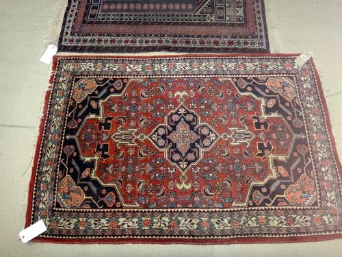 A Sarough rug, Persian, the madder field with black medallion, matching spandrels, an ivory flowering border, 158cm x 105cm, and a Baluchistan prayer