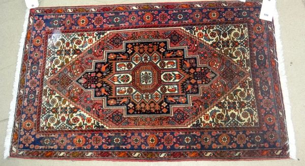 A Sarough rug, Persian, the madder floral field with stepped black medallion, ivory spandrels, an indigo flowerhead border, 125cm x 76cm, and an Afsha