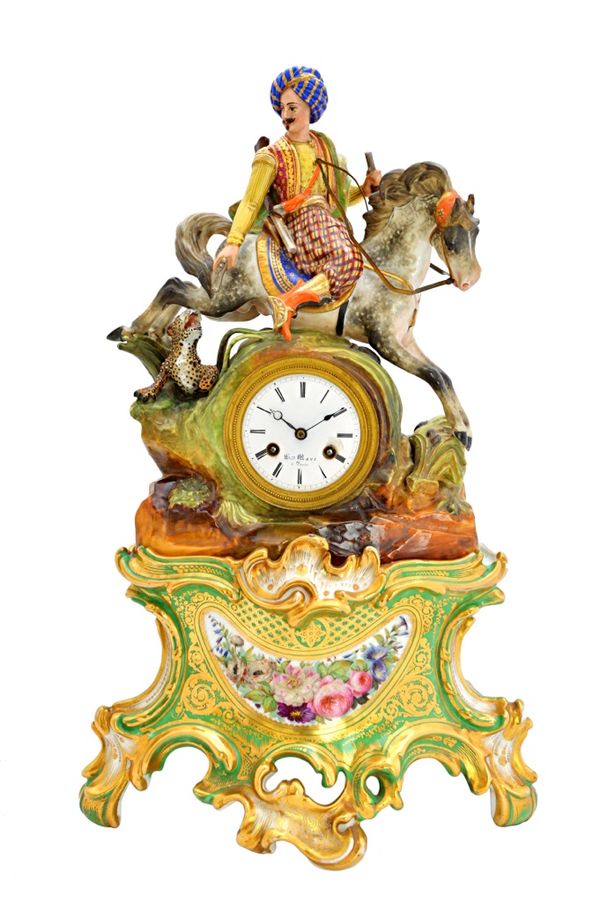 A porcelain mantel clock on stand, 'Hun figure', mid-19th century, probably by Jacob Petit, the white enamel dial detailed 'Hry Marc a Paris', enclosi