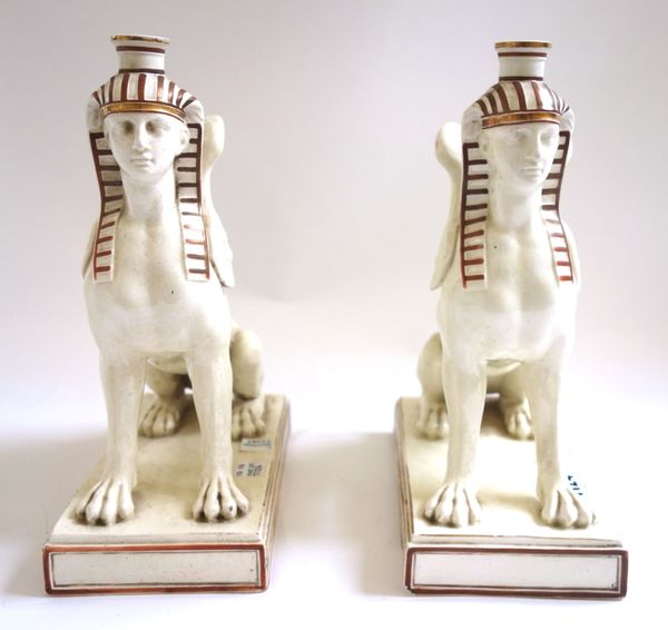 A pair of Wedgwood creamware figural candlesticks, late 19th century, each modelled as an anthropomorphic griffin with the face of an Egyptian male, s