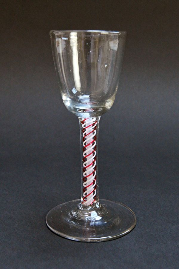 A colour twist wine glass, probably early 19th century, with rounded funnel bowl and red and white opaque twist stem, 13.5cm high. Illustrated