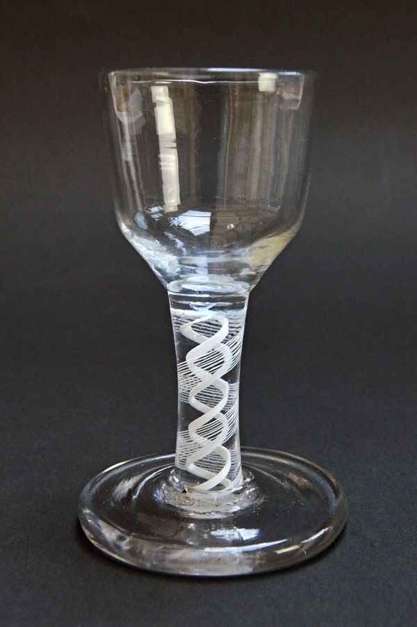 An 18th century firing glass, circa 1765, with ogee bowl and double series opaque twist stem, 10.5cm high. Illustrated