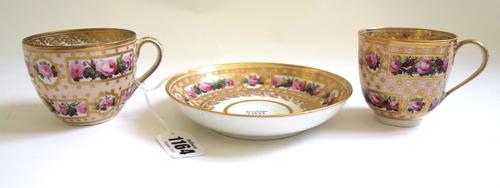 A Derby porcelain trio, circa 1787-90, in pattern 269, painted with panels of pink roses reserved on a salmon-pink ground gilt with stars and white en