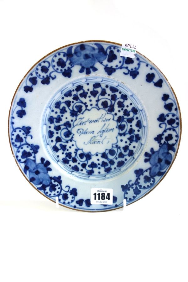 A small Dutch Delft blue and white plate, late 17th century, painted with an Oriental standing in a landscape with further figures in the border, 21cm