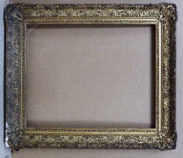 A 19th century gilt plaster frame with foliate decoration, the aperture 54cm wide x 67cm high.