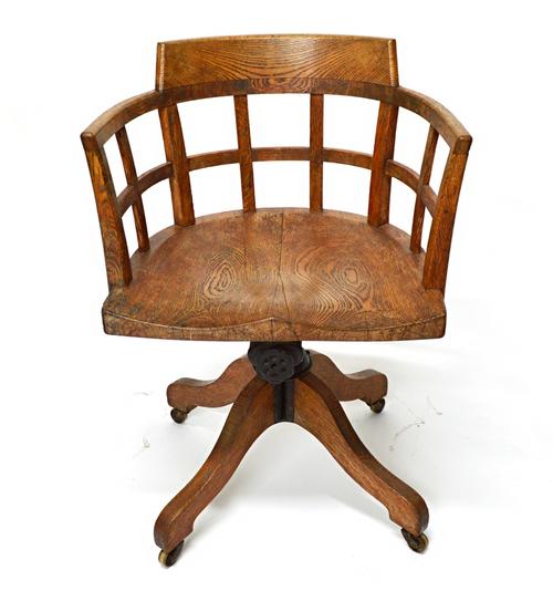 An early 20th century oak lattice tub back swivel office chair on four down swept supports.  Illustrated