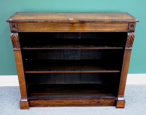 An early 19th century crossbanded rosewood floor standing open bookcase, with flanking scroll brackets on plinth base, 107cm wide.