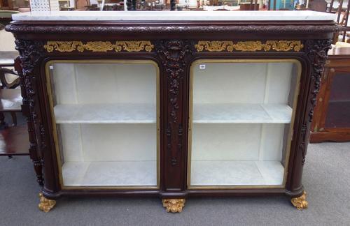 A late 19th century Italian display cabinet, the rounded rectangular marble top over and extensively carved gilt metal mounted mahogany glazed two doo