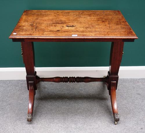 A George IV mahogany reading table the rectangular height and angle adjustable top on pair of trestle end standards united by turned stretcher on four