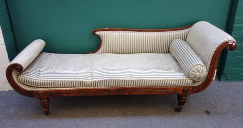 A Regency rosewood and faux rosewood chaise longue with shaped back and roll over in/out ends on tapering reeded supports, 200cm wide.