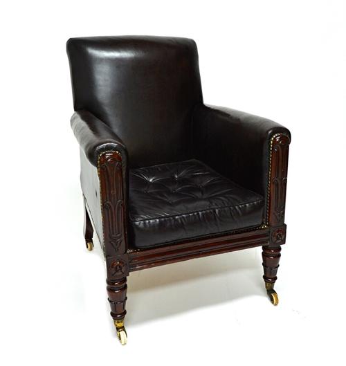 A William IV mahogany framed square back studded leather upholstered easy armchair on lappet carved front supports.  Illustrated
