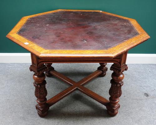 Howard & Sons, a Victorian oak centre table, the leather inset octagonal top on four acanthus carved bulbous supports united by stretcher, 116cm wide.