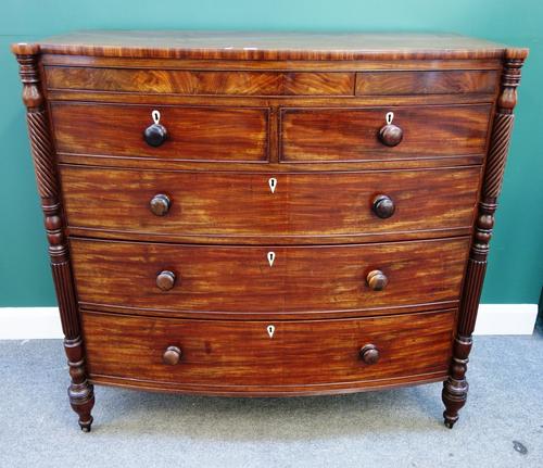 A large George IV mahogany bowfront chest of two short and three long graduated drawers, flanked by spiral and fluted outstepped corners, 131cm wide.
