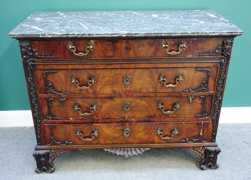 A 19th century French commode, the rectangular grey marble top over carved mahogany base of four long drawers, on pierced bracket feet, 120cm wide.