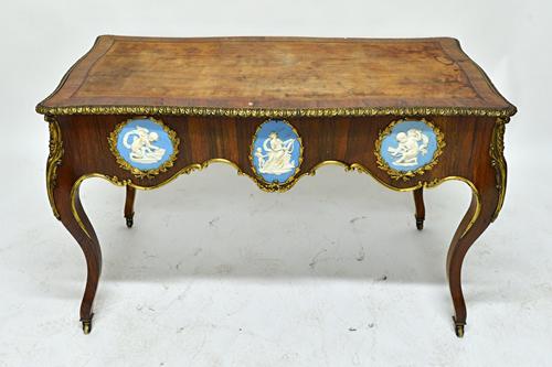 A 19th century gilt metal mounted rosewood centre writing table, the serpentine rectangular top over a shaped frieze with end drawers, also mounted wi