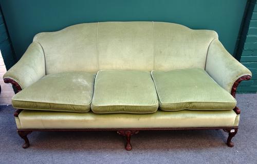 An 18th century style sofa, with hump back and roll over arms, on a carved mahogany frame, with three squat cabriole front supports, 207cm wide.