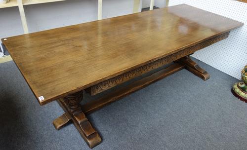A 17th century style oak refectory table, the rectangular top over carved frieze and bulbous supports, united by stretcher, 90cm wide x 245cm long.