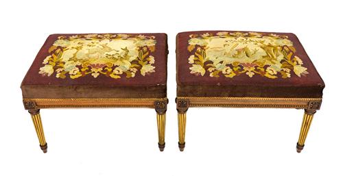 A pair of early 20th century French Louis XVI style walnut framed rectangular foot stools on gilt highlighted tapering fluted supports, 60cm wide.  Il
