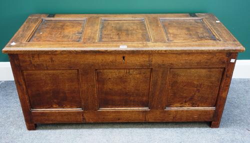 An early 18th century oak coffer, with triple panelled lid and front, on stile feet, 113cm wide.