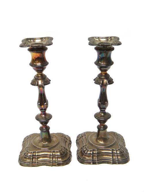 A pair of silver table candlesticks, each in a late 18th century design and on a shaped square base, Sheffield 1905, height 24cm.