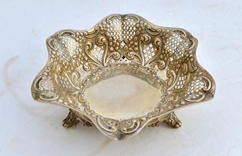 A late Victorian silver shaped hexagonal basket, with floral, foliate and scroll embossed and pierced decoration, raised on three feet, Sheffield 1899
