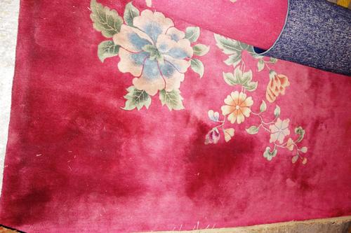 A Chinese carpet, the plum field with diagonal sprays of water plants, 354cm x 272cm and a plain dark indigo Chinese rug, 180cm x 118cm, (2).  H8