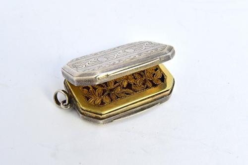 A George III silver cut cornered rectangular vinaigrette, with a floral and foliate engraved and pierced grille, the exterior with engraved decoration