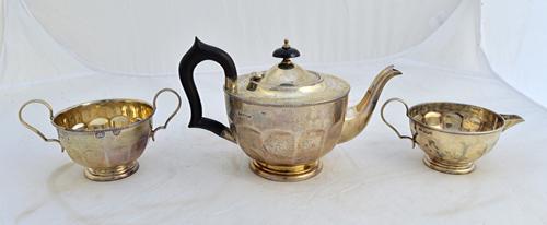 A silver three piece tea set, comprising; a teapot, a twin handled sugar bowl and a milk jug, each piece of panelled circular form within beaded rims,