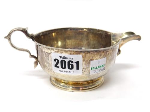 A silver milk jug, of circular form, with a scrolling handle and on a circular foot, retailed by Tessiers Ltd, London, London 1937, weight 250 gms.