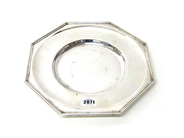 A silver octagonal dished plate, having a reeded rim, by Garrard & Co Ltd, diameter 30cm, Sheffield 1985, weight 963 gms.